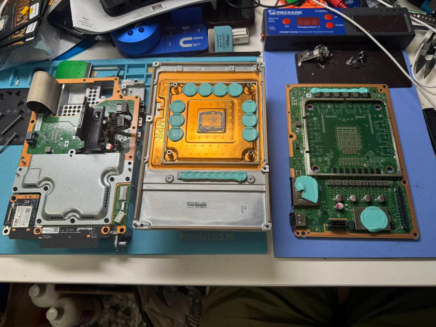 Full Xbox Series X teardown: chassis, copper vapor-chamber heatsink and mainboard laid out on the bench