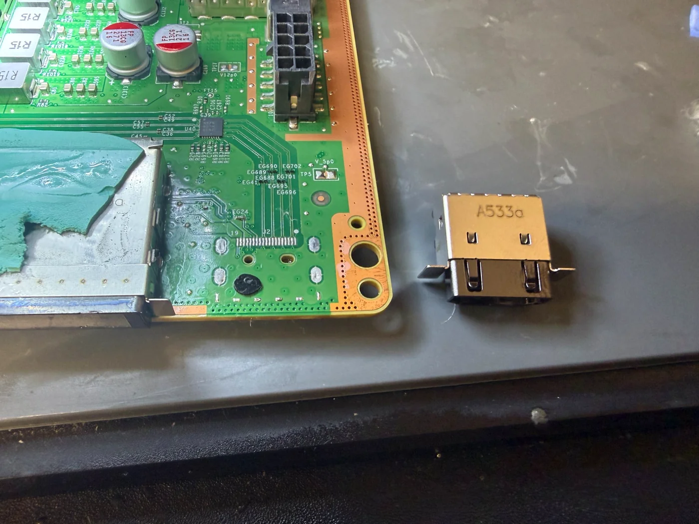 New HDMI port ready for installation next to the cleaned pads on the Xbox Series X mainboard