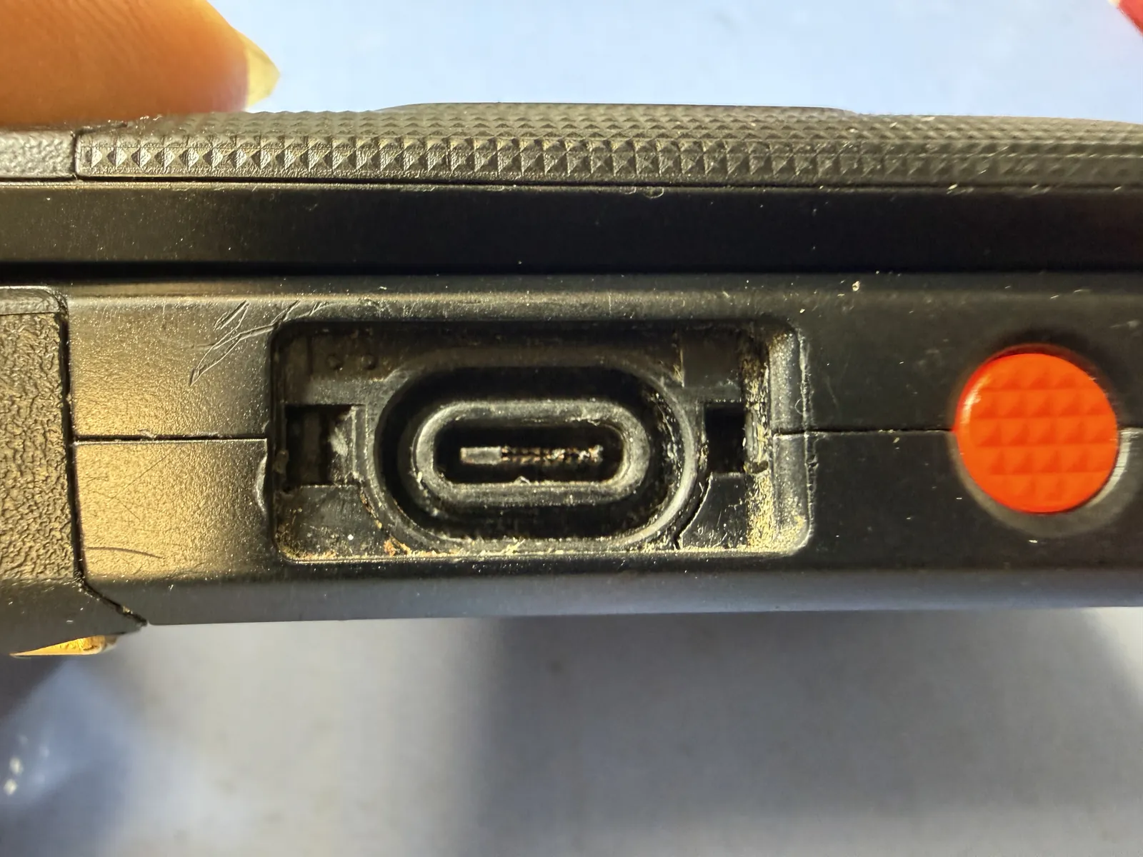 Kyocera DuraXA E4831 charging port before repair, opening broken and deformed