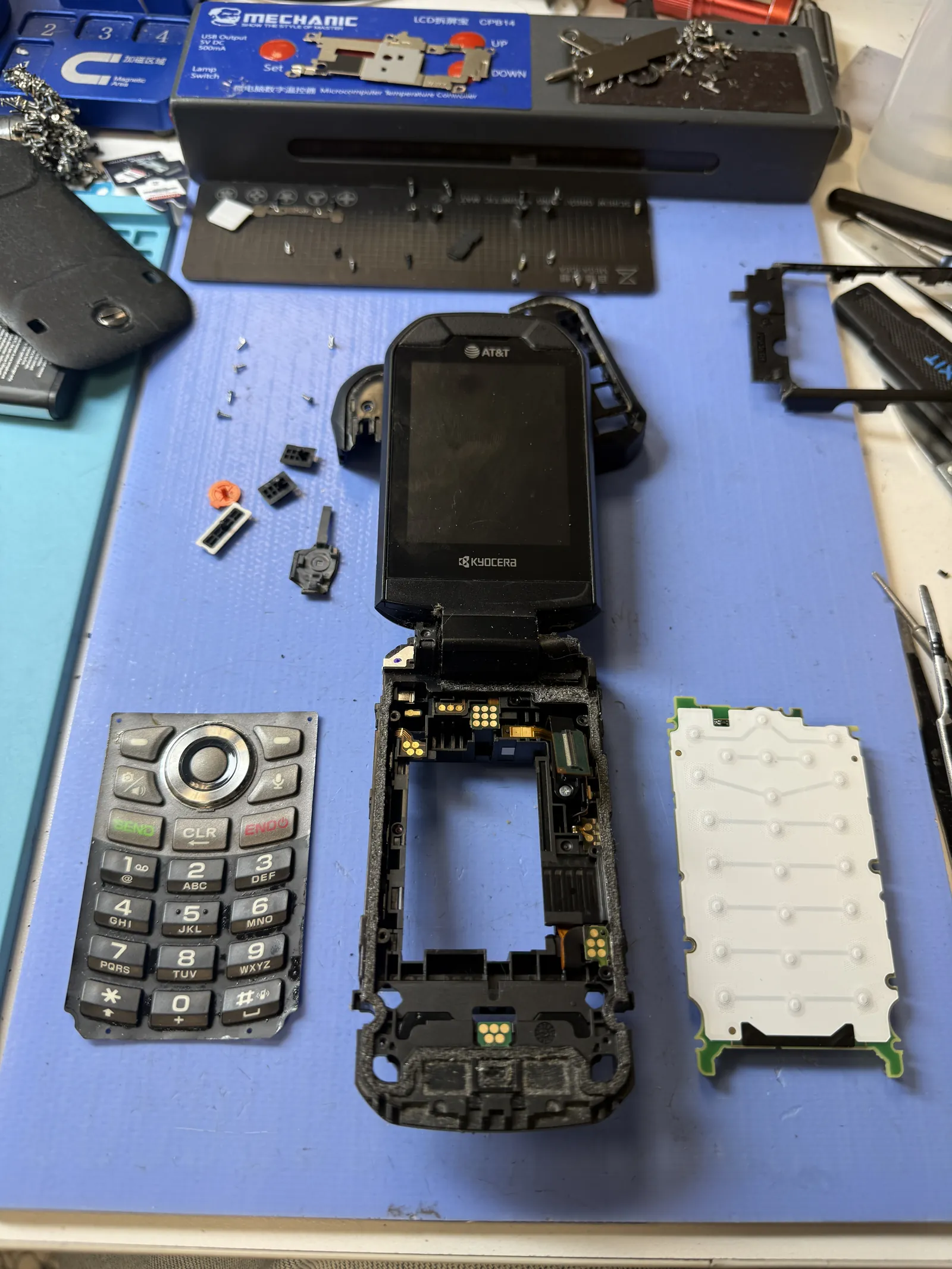 Kyocera DuraXA E4831 disassembled on the repair bench for charging port replacement