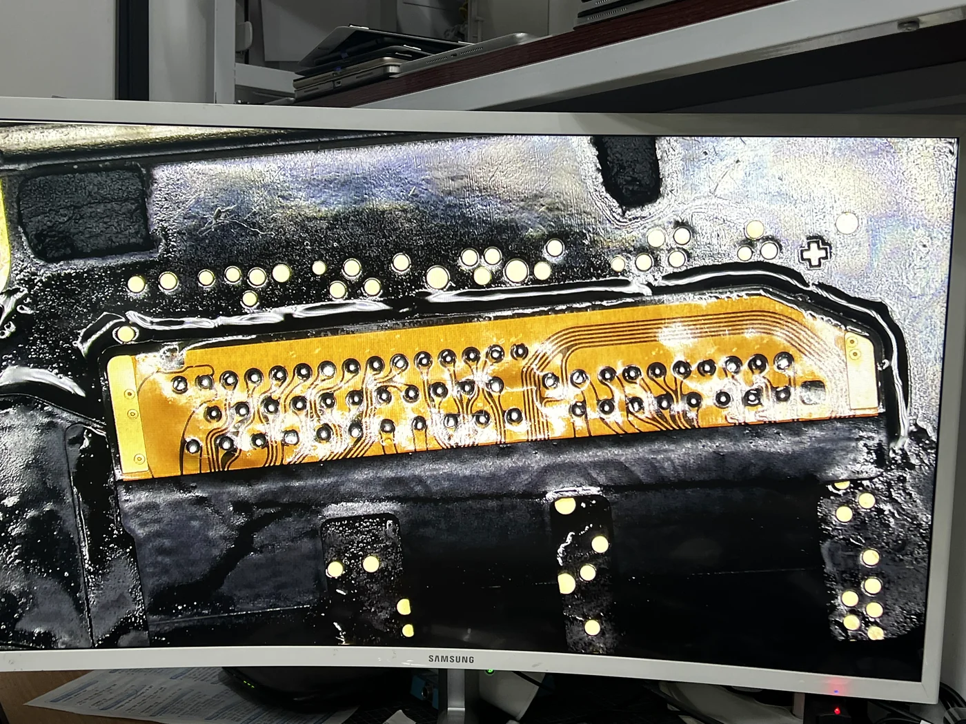 Microscope view of the Apple Watch Series 5 logic board pads with the new display flex being aligned for micro soldering