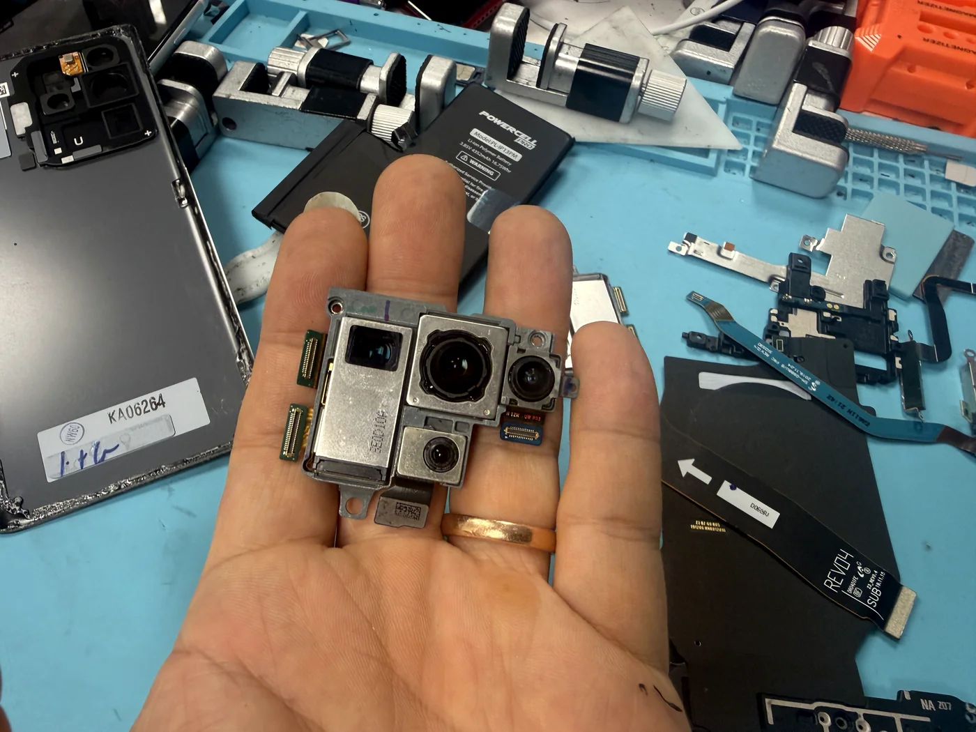Genuine Samsung Galaxy S20 Ultra rear camera module held on the bench during replacement for blurry photos