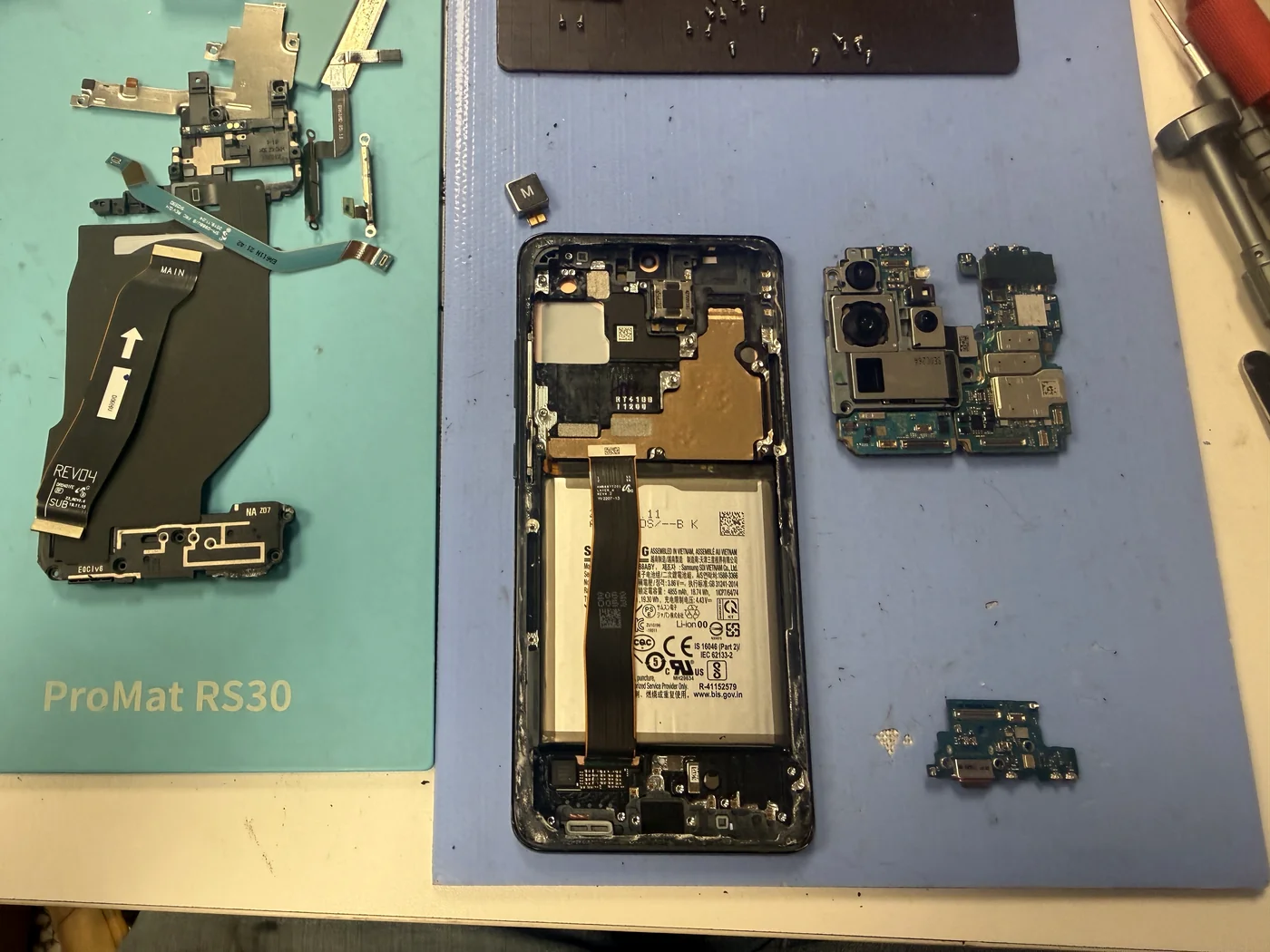 Galaxy S20 Ultra fully disassembled with logic board, camera module and charging port removed for screen replacement