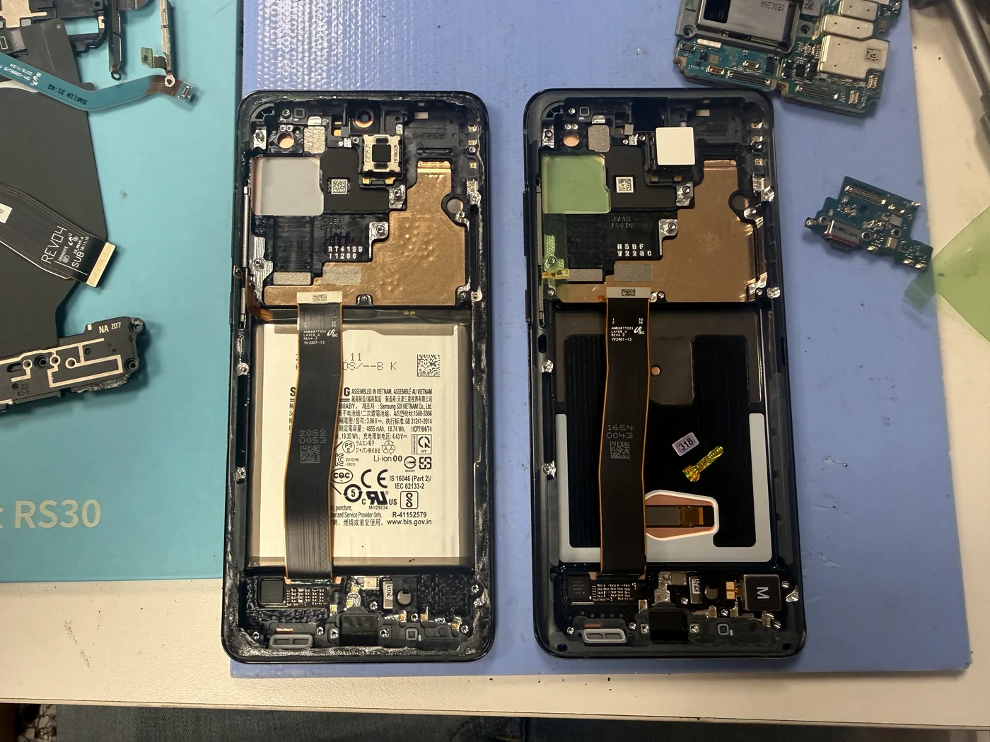 Old Galaxy S20 Ultra frame beside the new genuine Samsung screen assembly ready for parts transfer