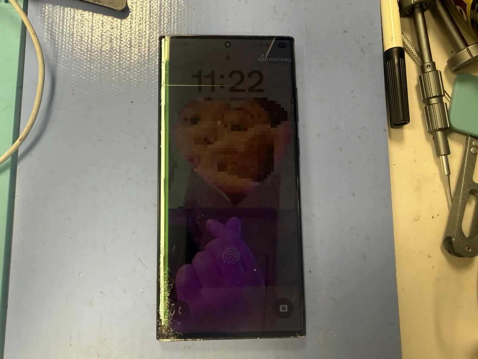 Galaxy S22 Ultra with a shattered screen along the left edge, as it arrived at the shop