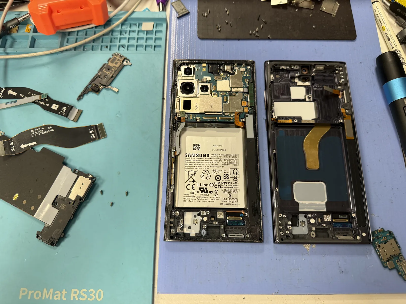 Every internal part being transferred from the cracked Galaxy S22 Ultra into the new screen assembly