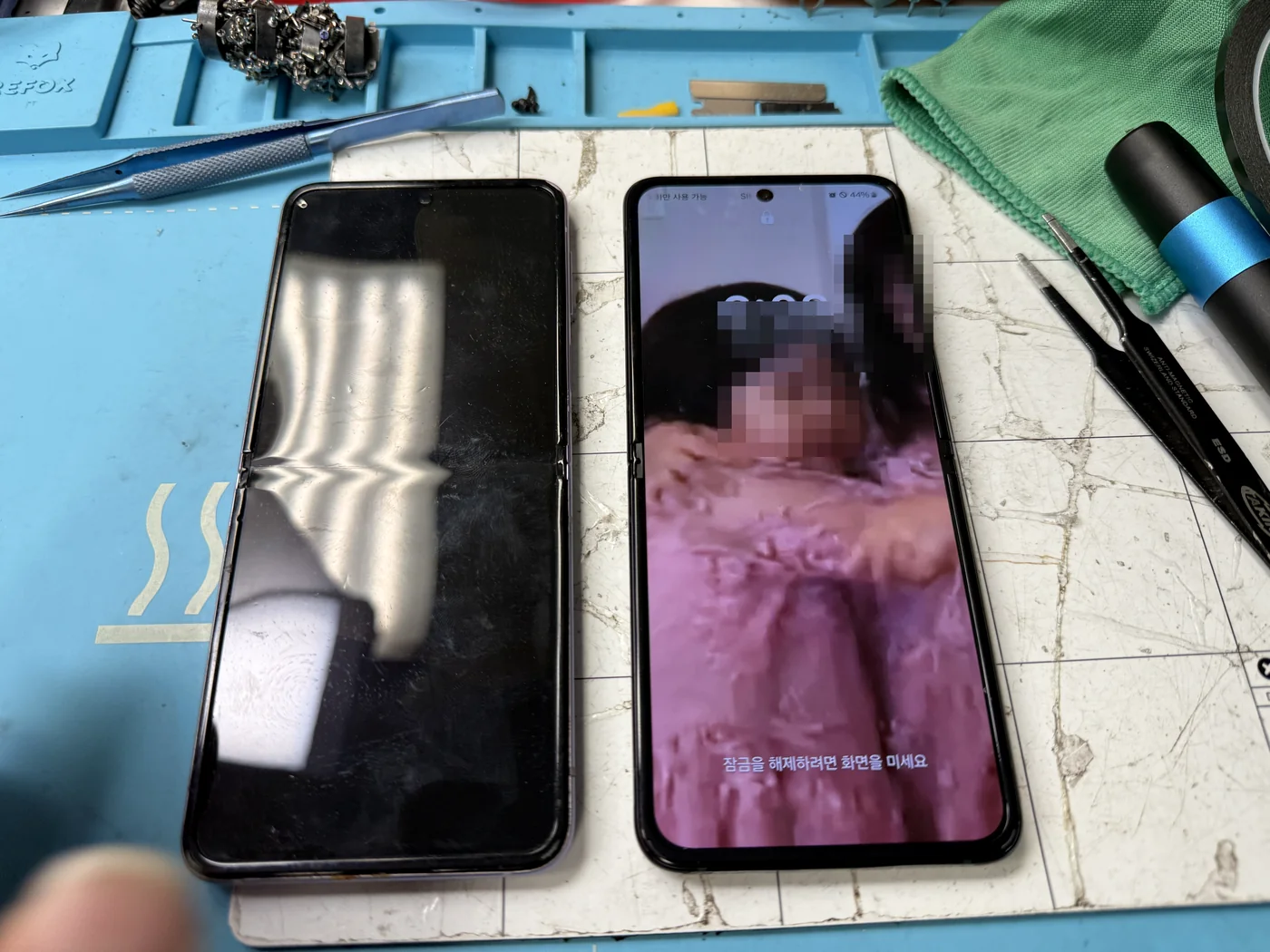 Repaired Galaxy Z Flip 3 running on its new genuine Samsung display next to the removed damaged screen
