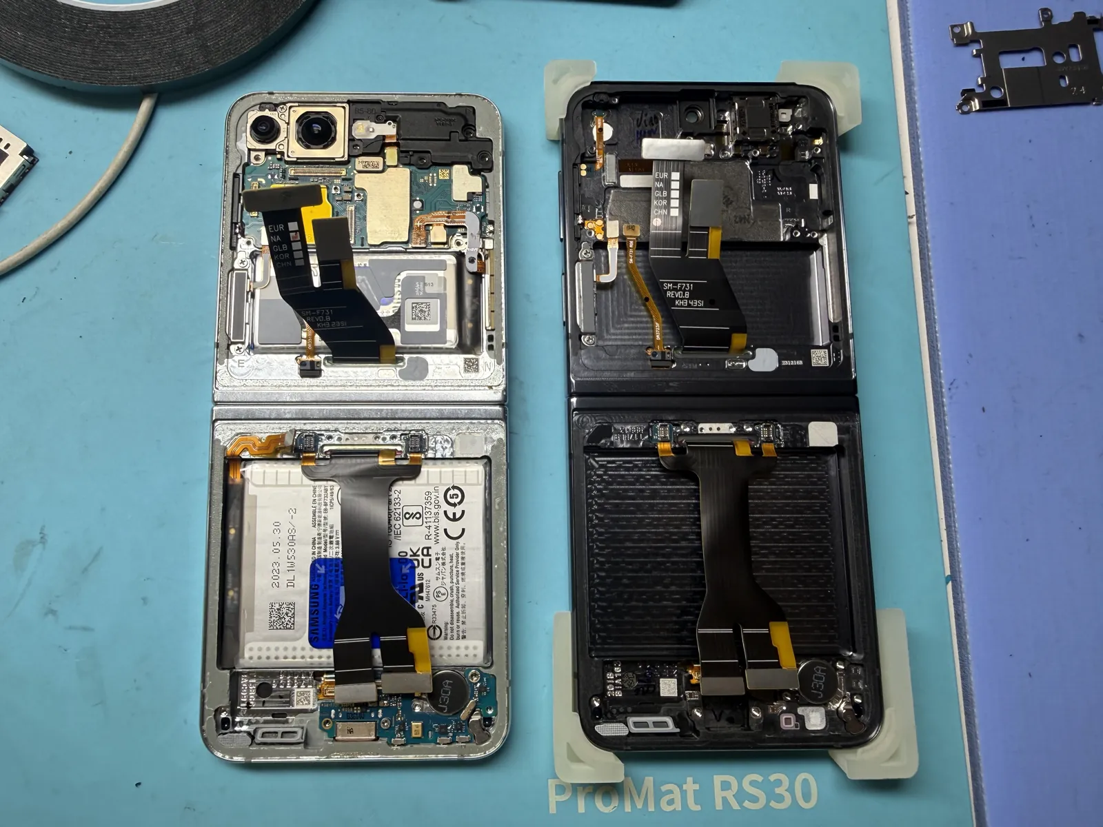 New Galaxy Z Flip 5 inner screen assembly with its hinge cable laid beside the opened frame