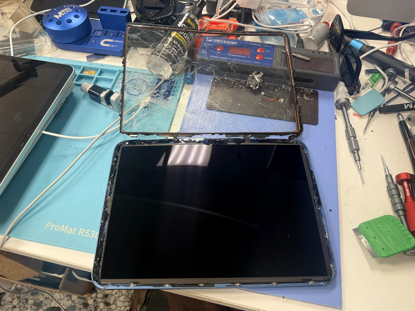Cracked digitizer glass lifted off the iPad 11-inch (2025), original LCD still sitting in the bent frame