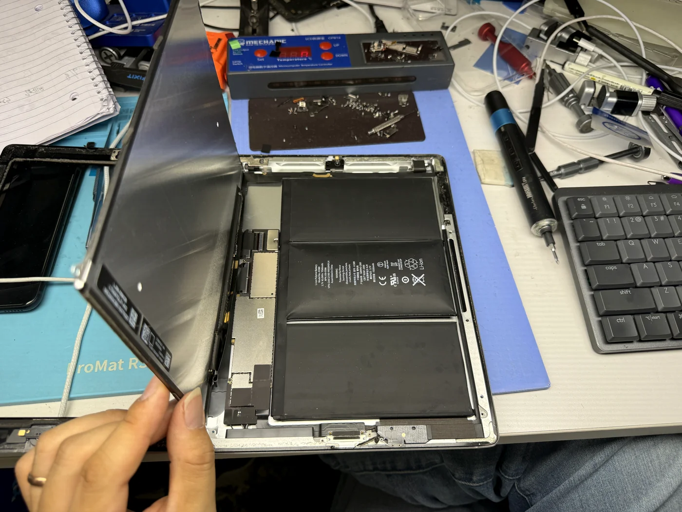 iPad 3 LCD carefully lifted away, revealing the swollen battery sitting behind it in the frame