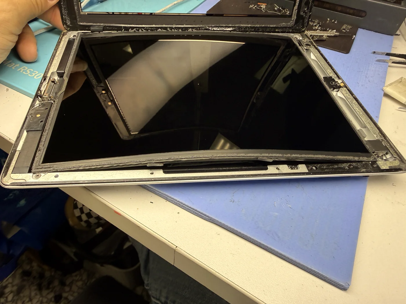 iPad 3 opened on the bench showing the LCD bowed upward by the swollen battery underneath it