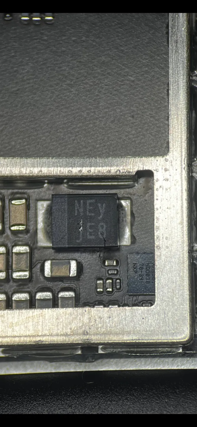 Close-up of the crack running across the damaged chip on the iPad 7th gen board