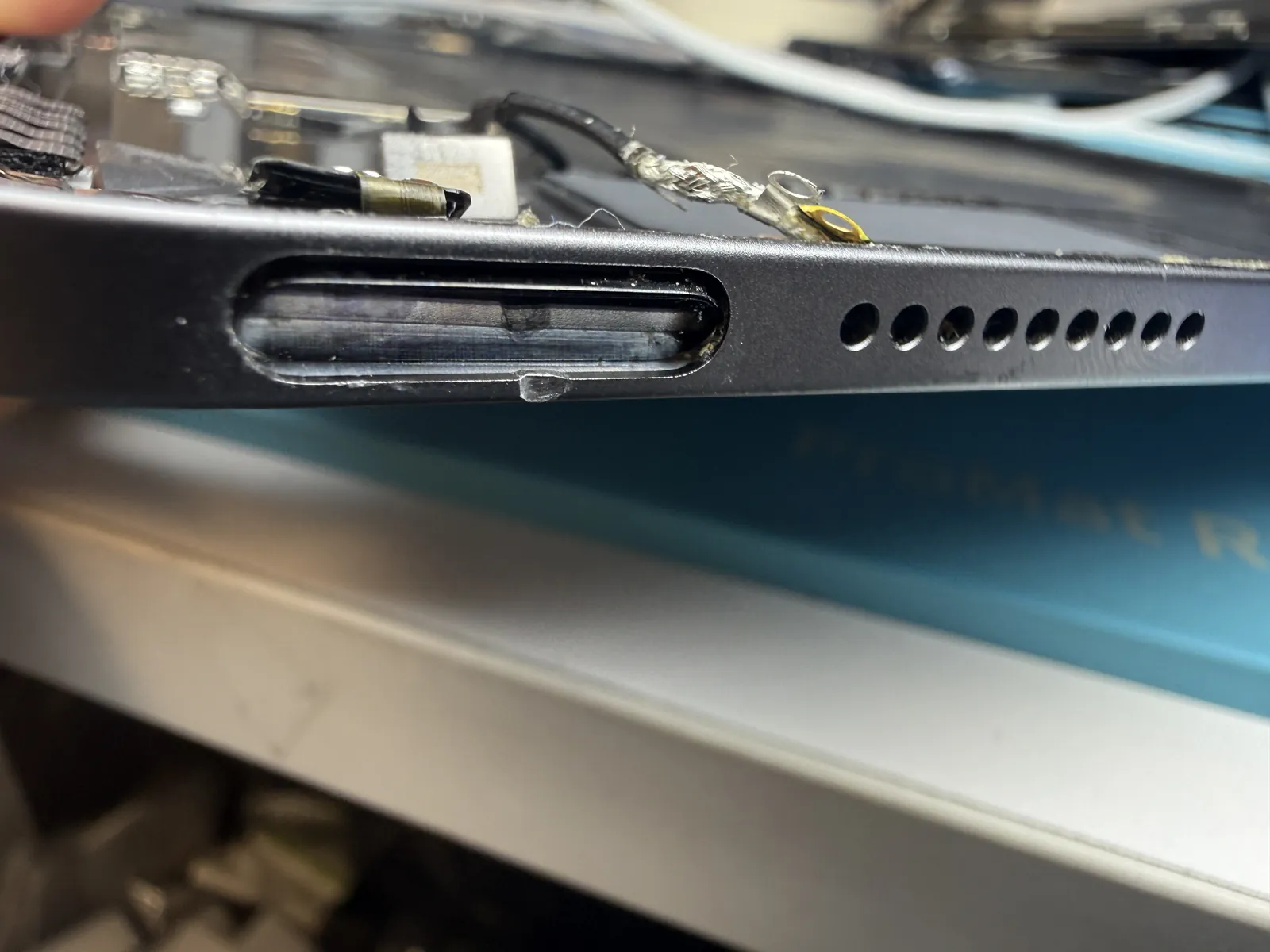 Close-up of the deformed button channel in the iPad Air 4 frame after the drop