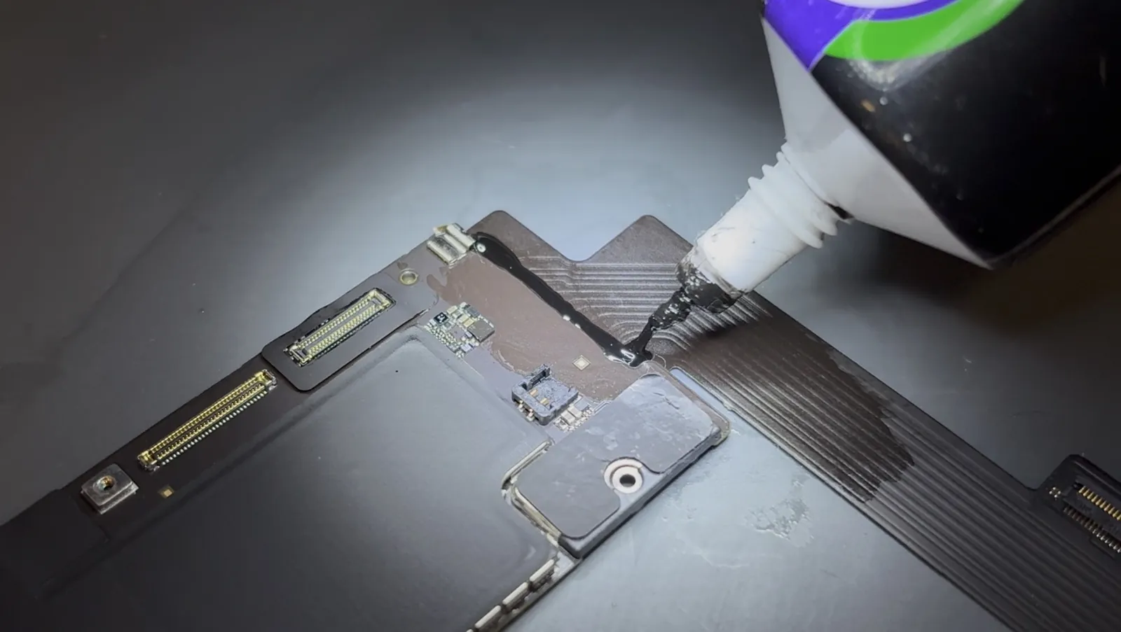 Adhesive applied over the soldered iPad Air 4 charging port so the joints stay put