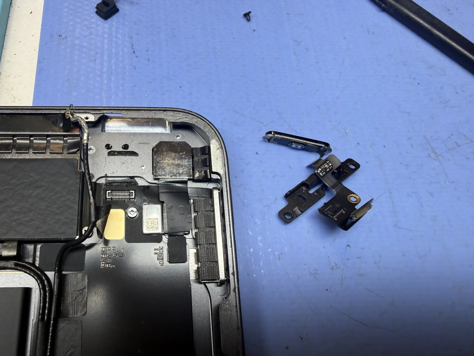 The iPad Air 4 power button and its bracket removed from the corner of the frame