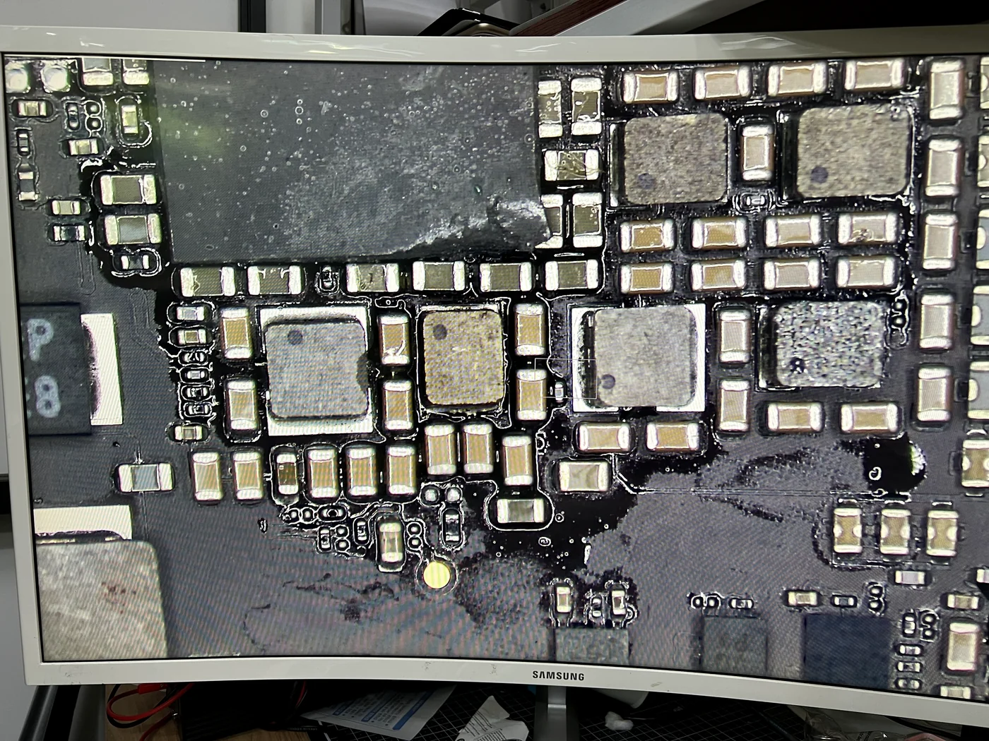 Microscope view of a donor iPad Pro 10.5 logic board while the replacement power coil is harvested