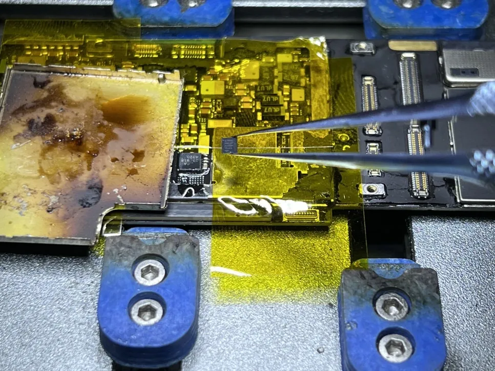 Placing the replacement charging chip onto the iPad Pro 11 board with tweezers