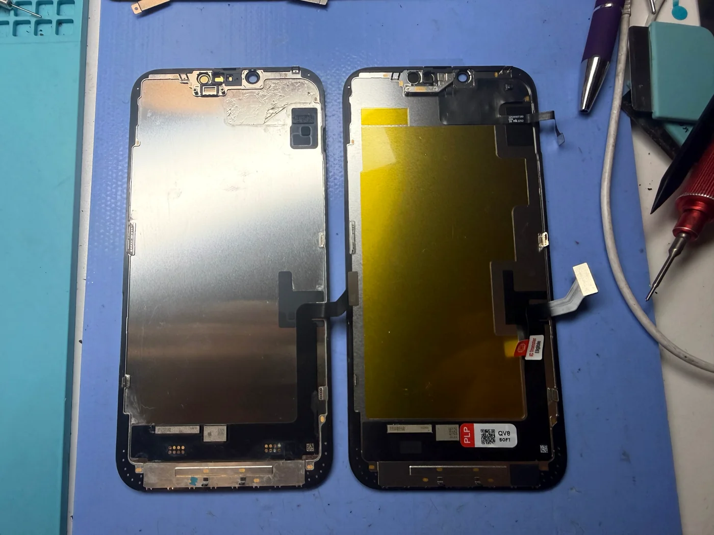 Old water-damaged iPhone 14 Plus screen beside the new OLED replacement screen
