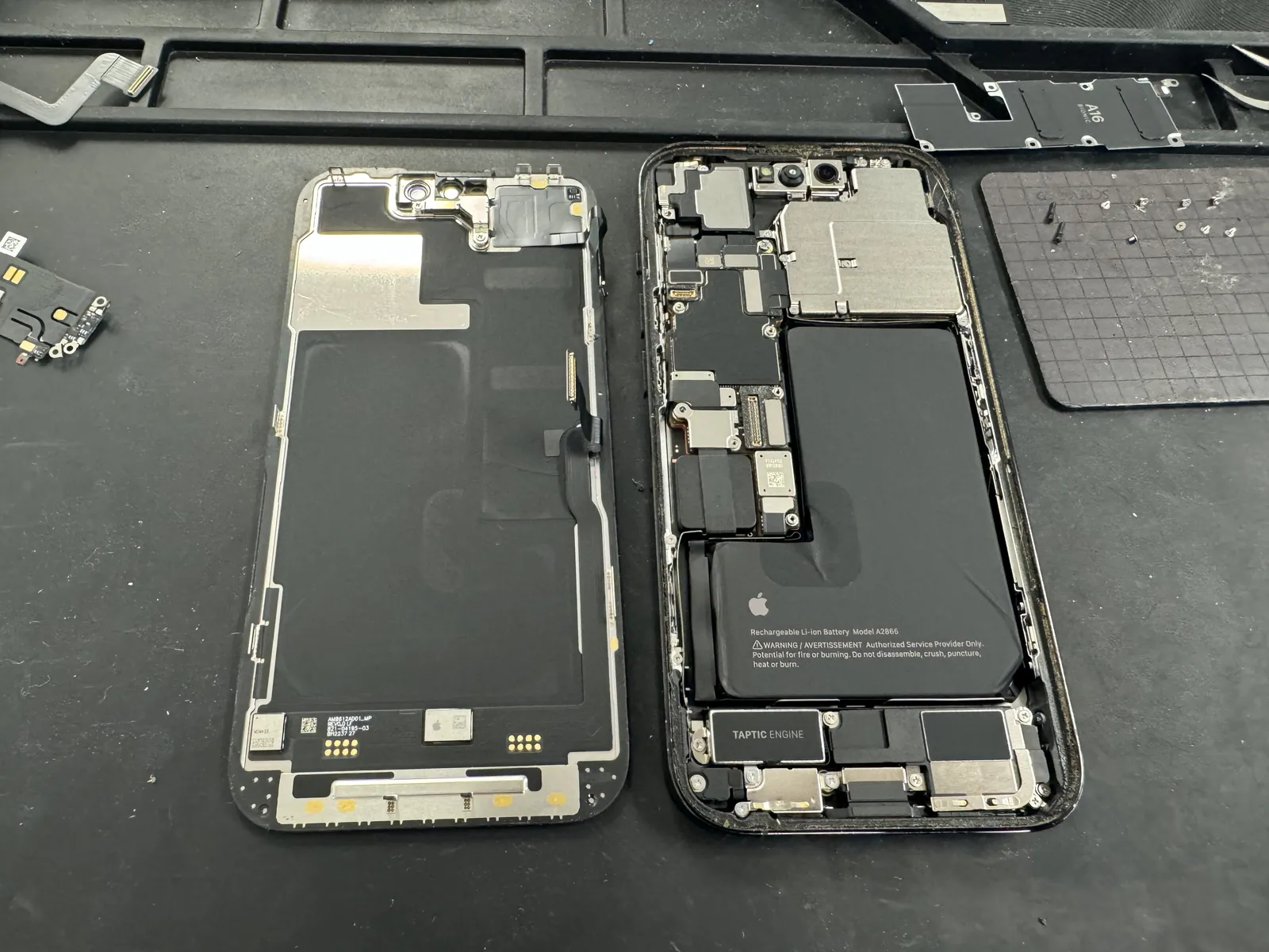 iPhone 14 Pro opened on the bench with the screen separated for charging port replacement