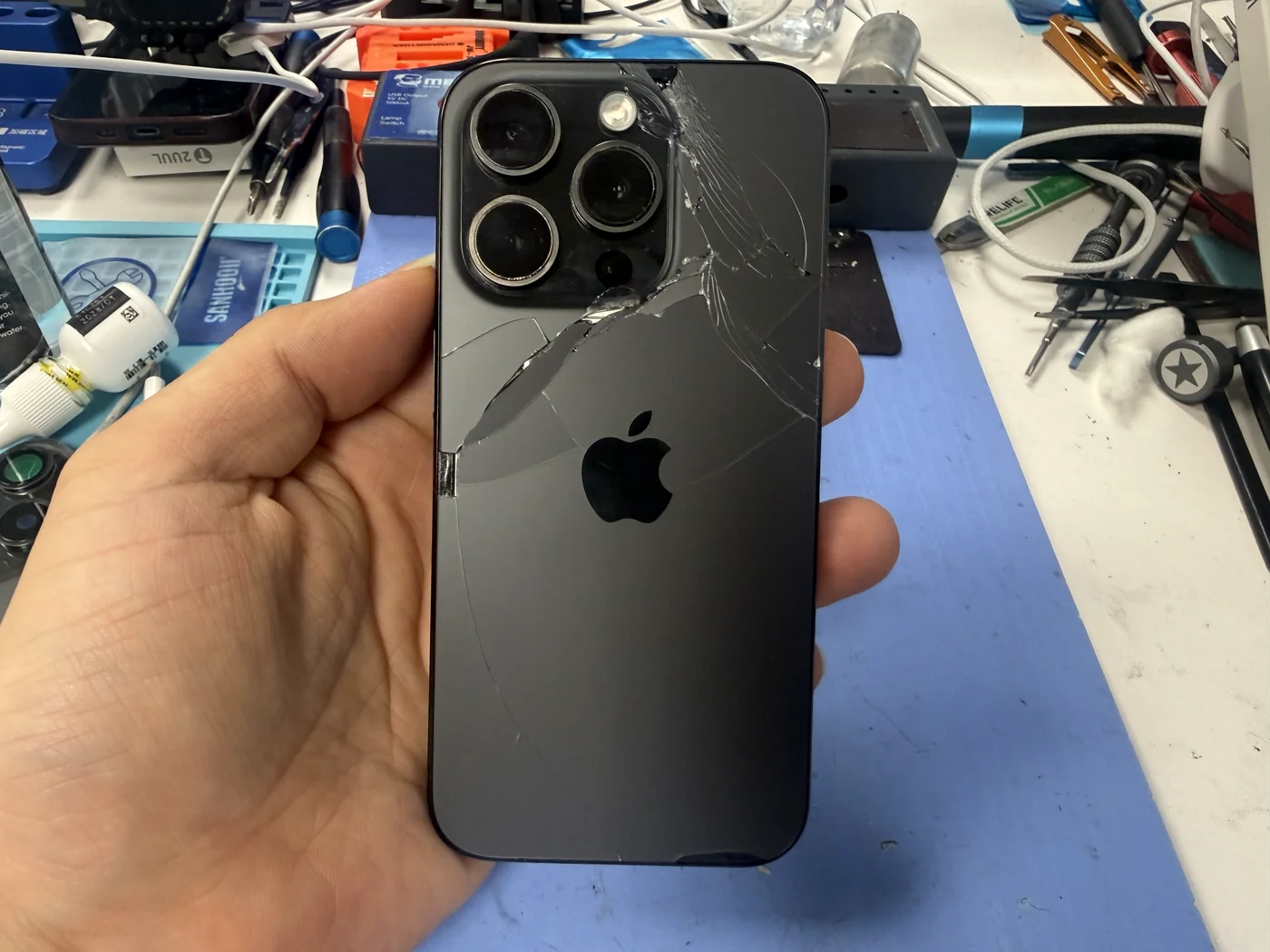 iPhone 15 Pro with a cracked aftermarket back glass checked in for replacement at FIXSTORY DTLA, Downtown Los Angeles