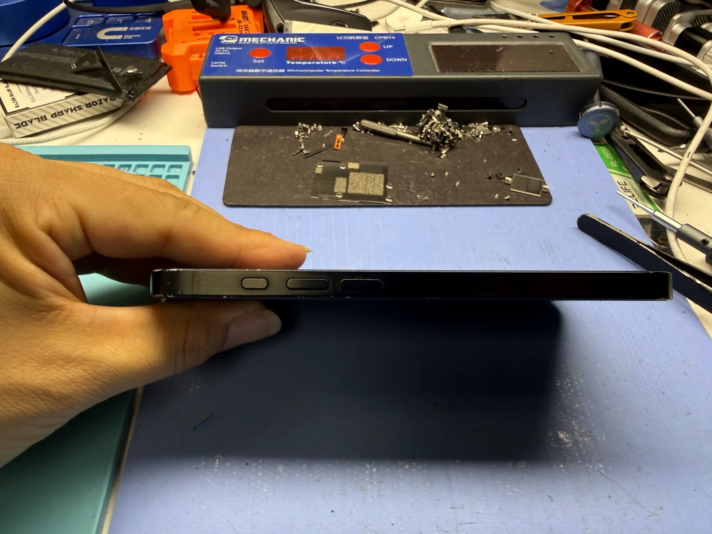 iPhone 16e edge-on, flat again after swollen battery and back glass replacement