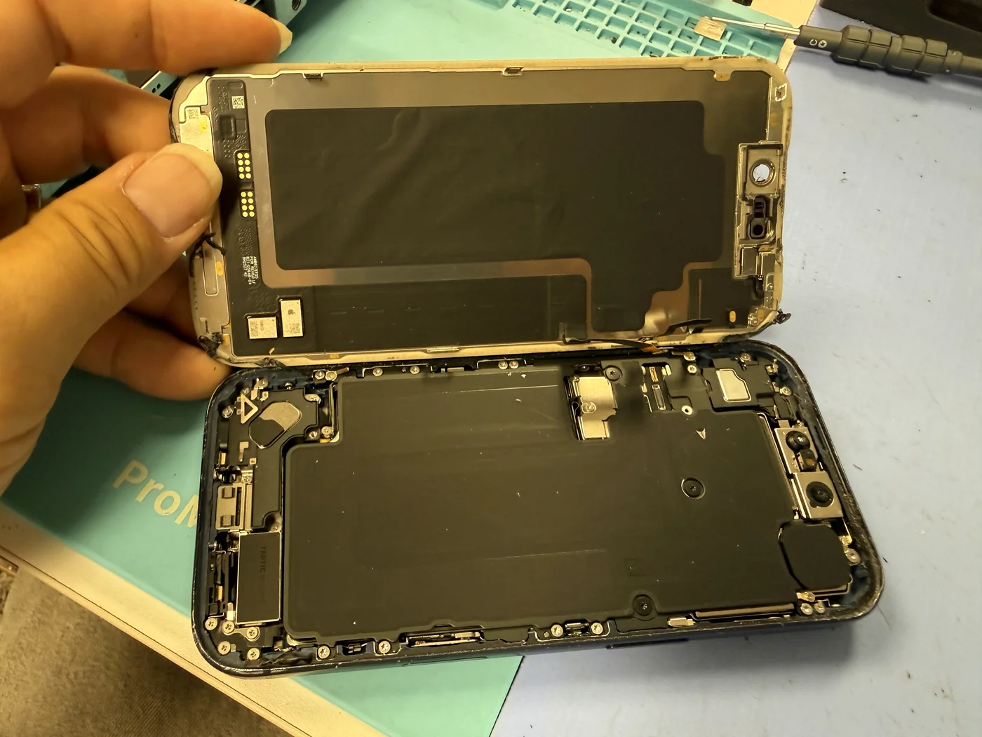 The broken screen lifted away from the iPhone 17 Pro chassis