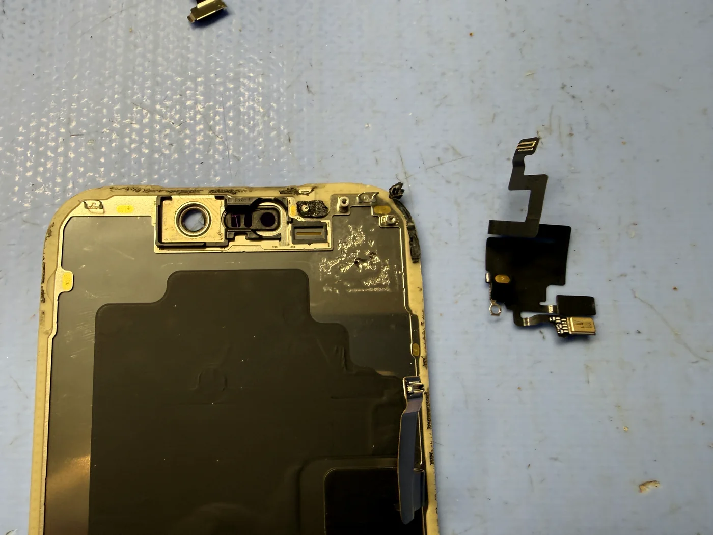 Proximity sensor assembly removed from the broken iPhone 17 Pro screen