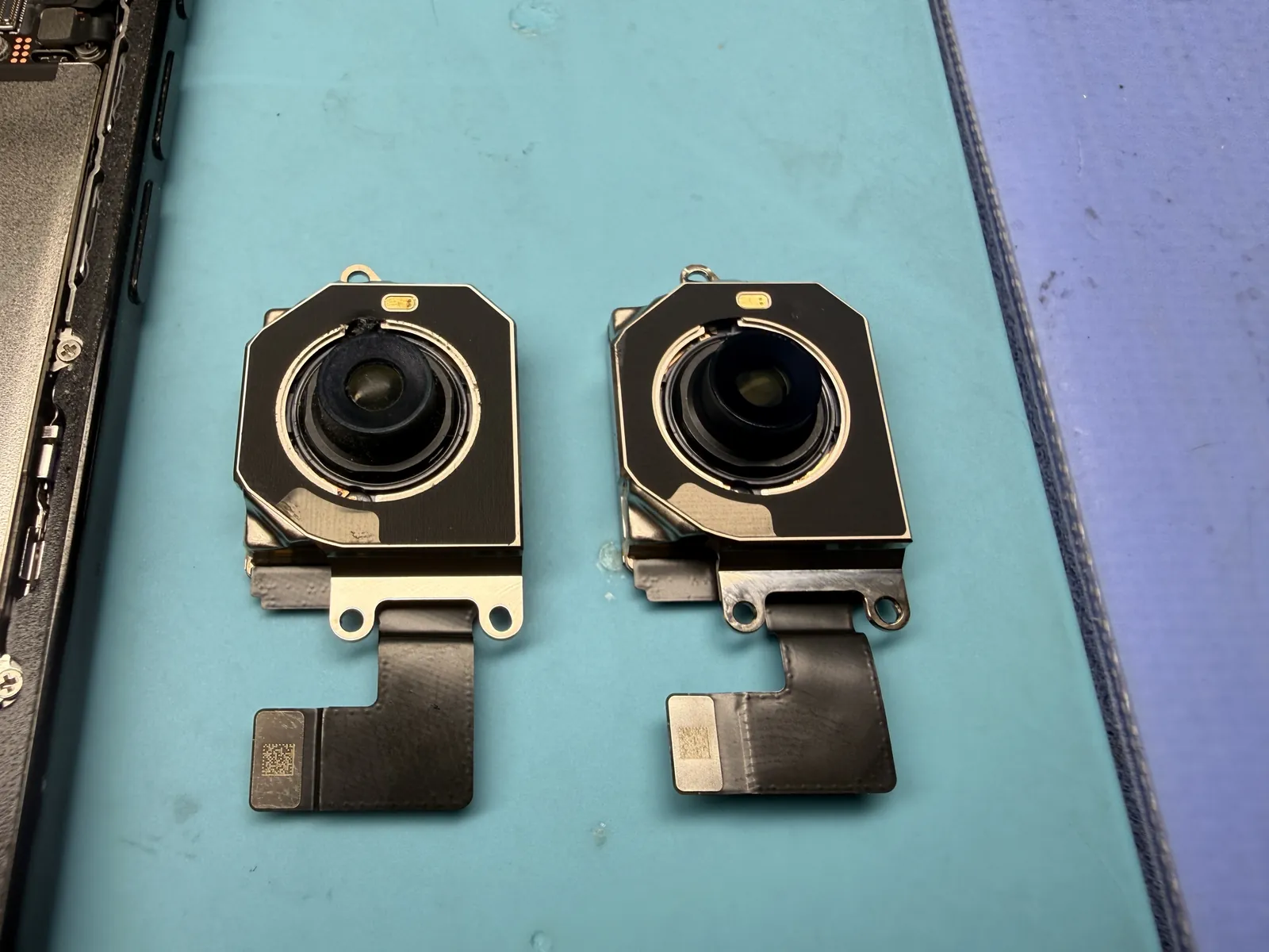 Side by side: the worn, dirty camera that came out on the left, the brand-new genuine Apple camera on the right
