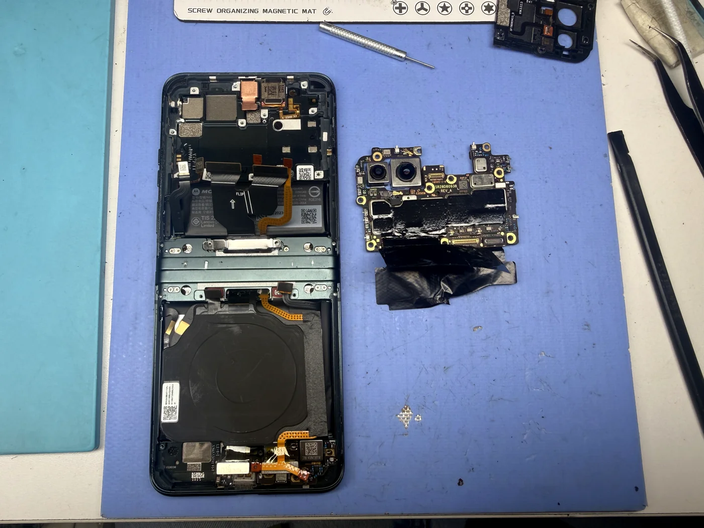 Motorola Razr 40 motherboard with cameras removed from the frame during folding screen replacement