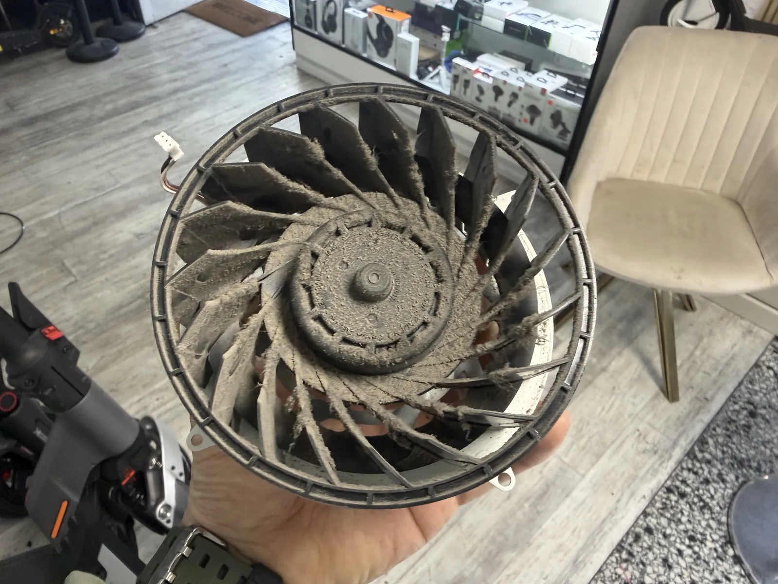 The PS5 fan removed from the console, every blade caked in dust