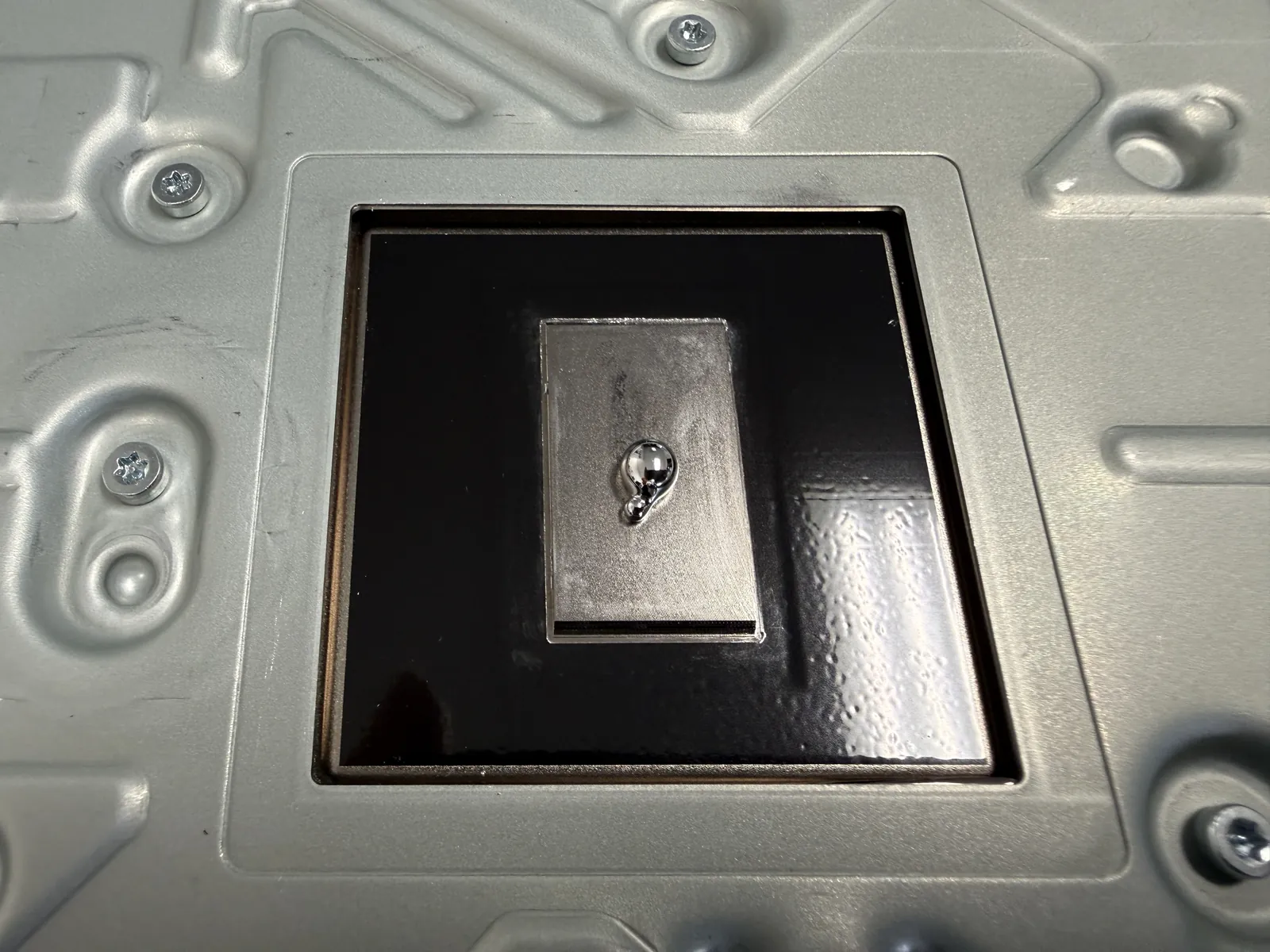 A fresh bead of liquid metal applied to the cleaned PS5 APU