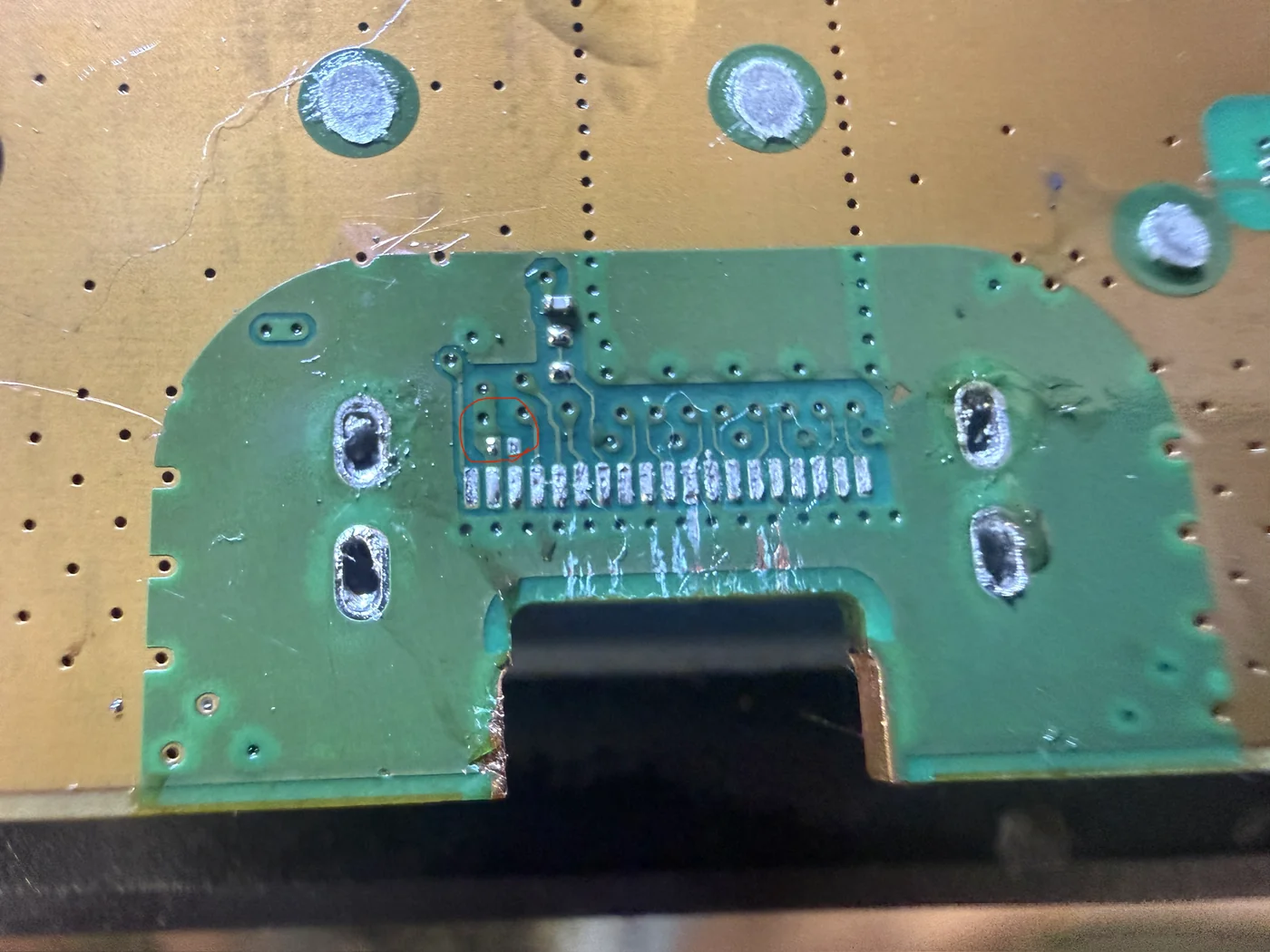 Close-up of the PS5 HDMI port footprint showing the empty pads of a capacitor knocked off by the broken port