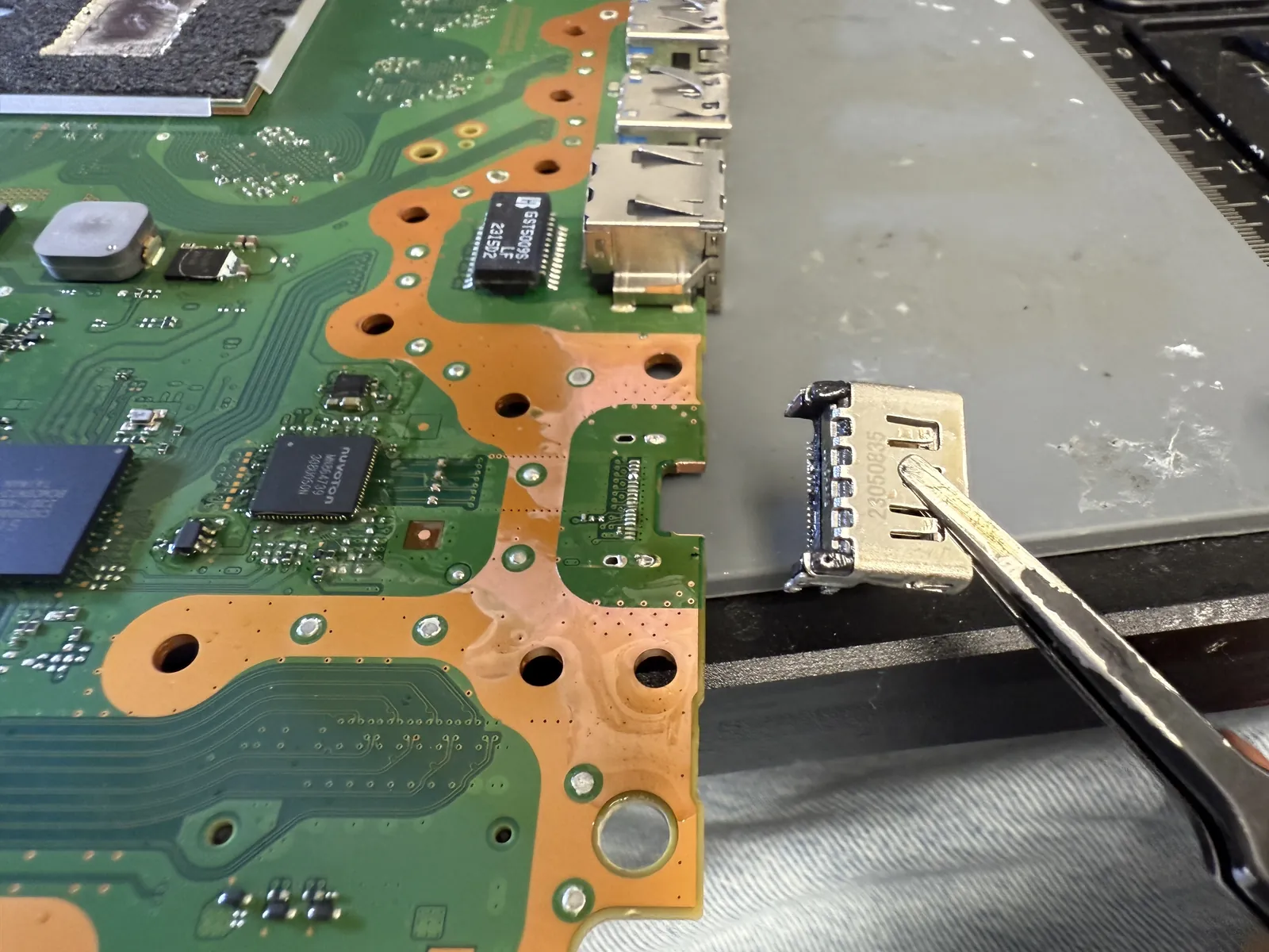 The damaged HDMI port removed from the PS5 mainboard with hot air