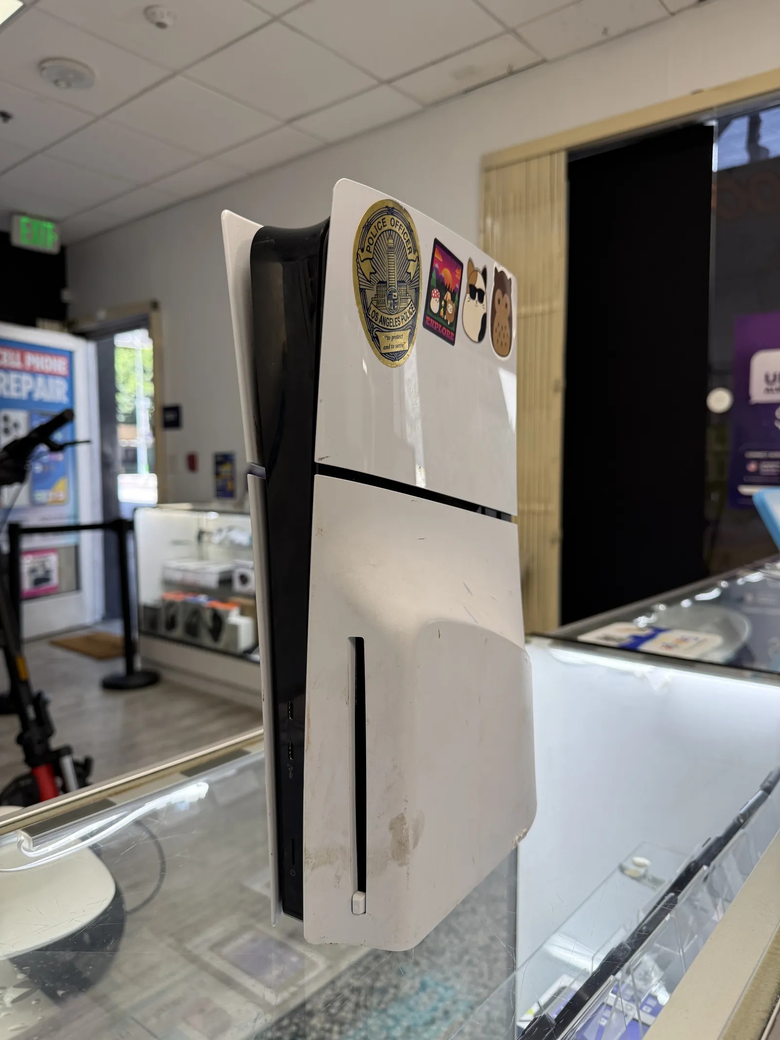 PS5 Slim brought in for HDMI port repair, standing on the shop counter