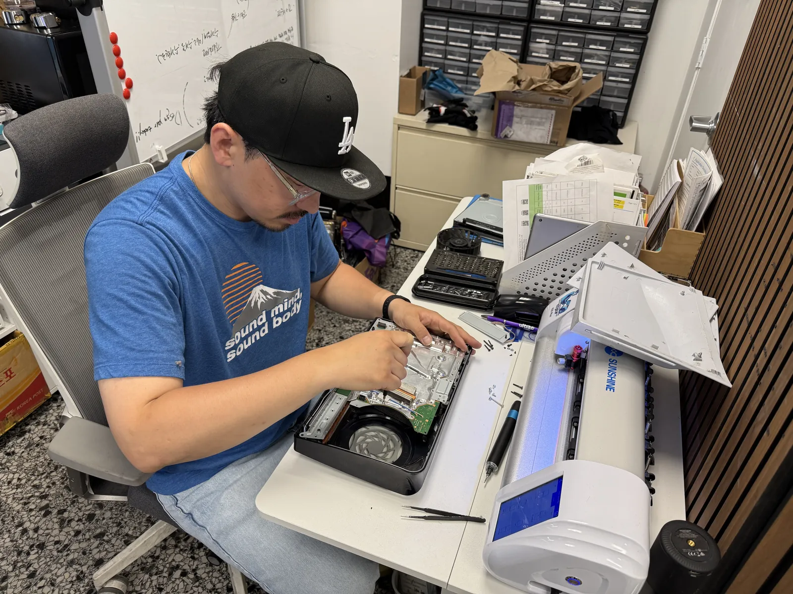 Technician opening the PS5 Slim to reach the mainboard