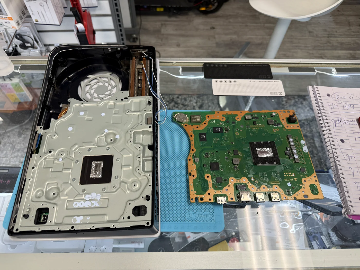 PS5 Slim torn down, chassis with heatsink on the left and the mainboard removed on the right
