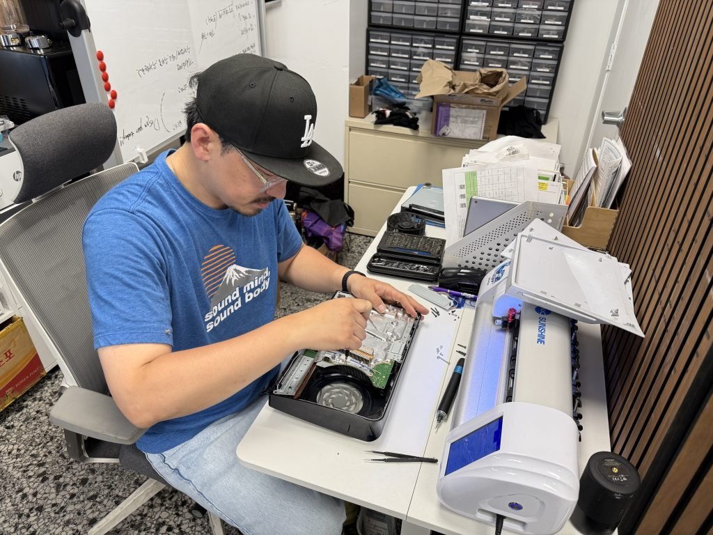Skilled technician repairing a Samsung phone or tablet at a workbench