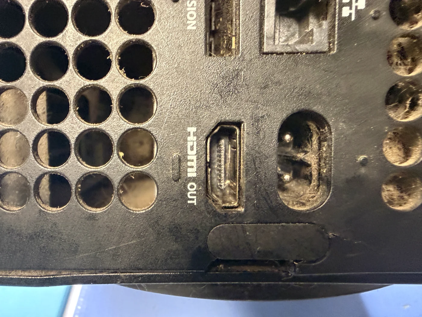 Xbox Series X back panel with dust and pet hair around the HDMI OUT port, power inlet and vents